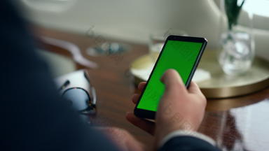商人手刷绿色智能手机屏幕特写镜头男人。模型设备